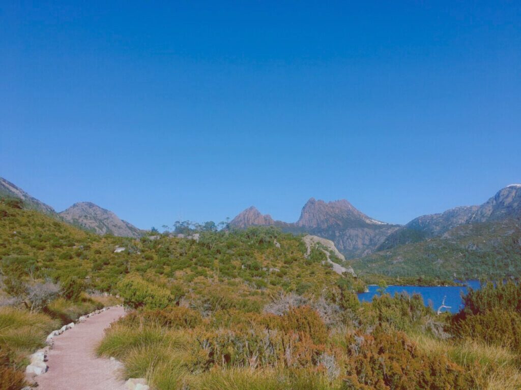 山と湖へ続く細いトレイルの風景｜自然の中を歩きながら心を整える自己対話の時間をイメージした山の景色
