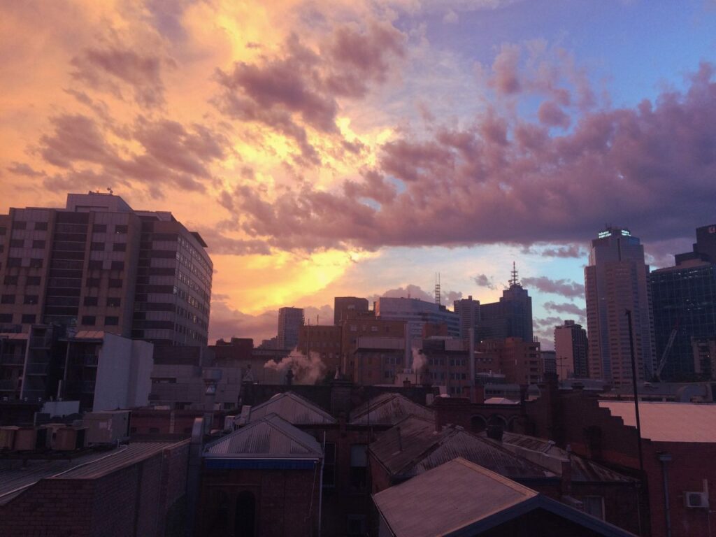 街の上に広がる夕焼け空と雲｜一日の終わりに思考を手放す時間をイメージした都市の夕景