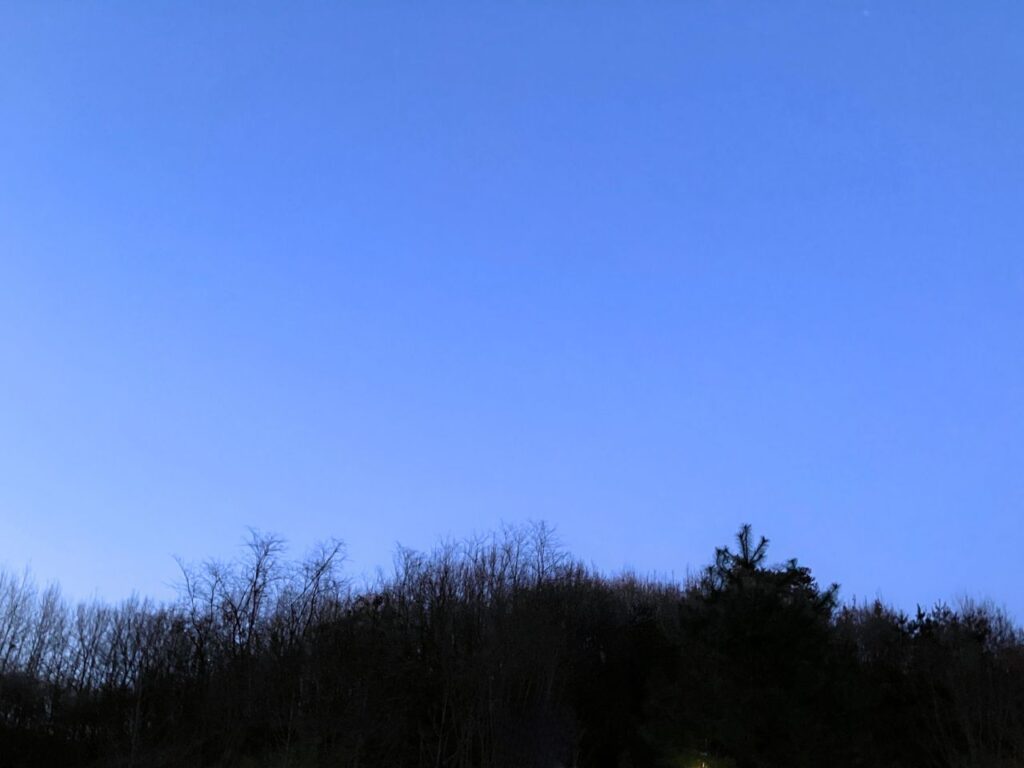 夕暮れの青い空と丘のシルエット｜静かな時間に心を落ち着ける内省の瞬間をイメージした空の風景