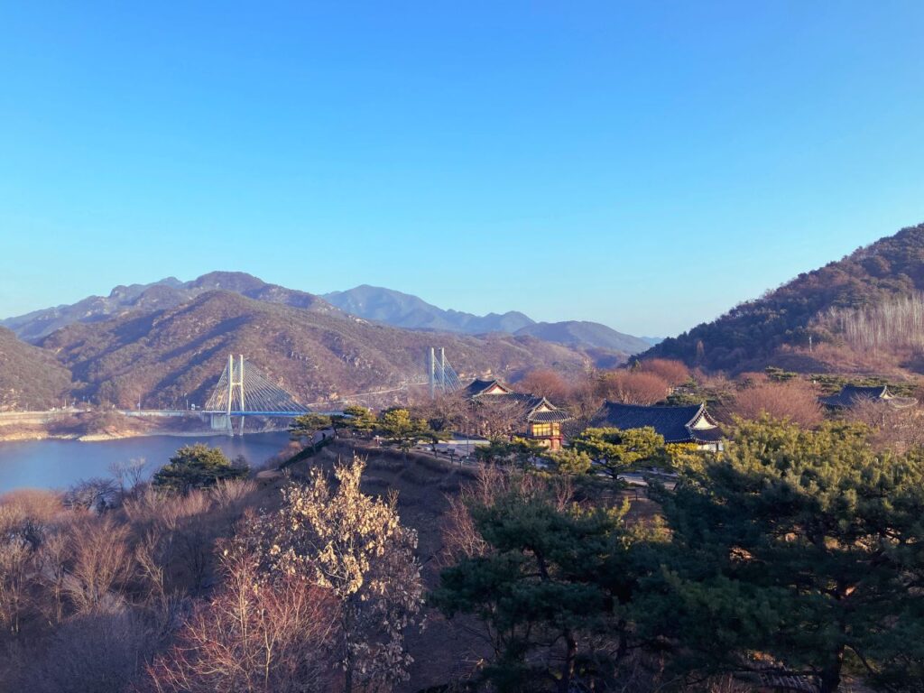 山々と川、遠くに橋が見える風景｜広い景色の中で心を落ち着ける内省の時間をイメージした自然の風景